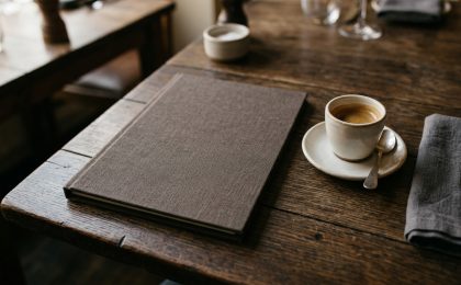 Ahşap masa üzerinde sade bir restoran menü tasarımı kapağı